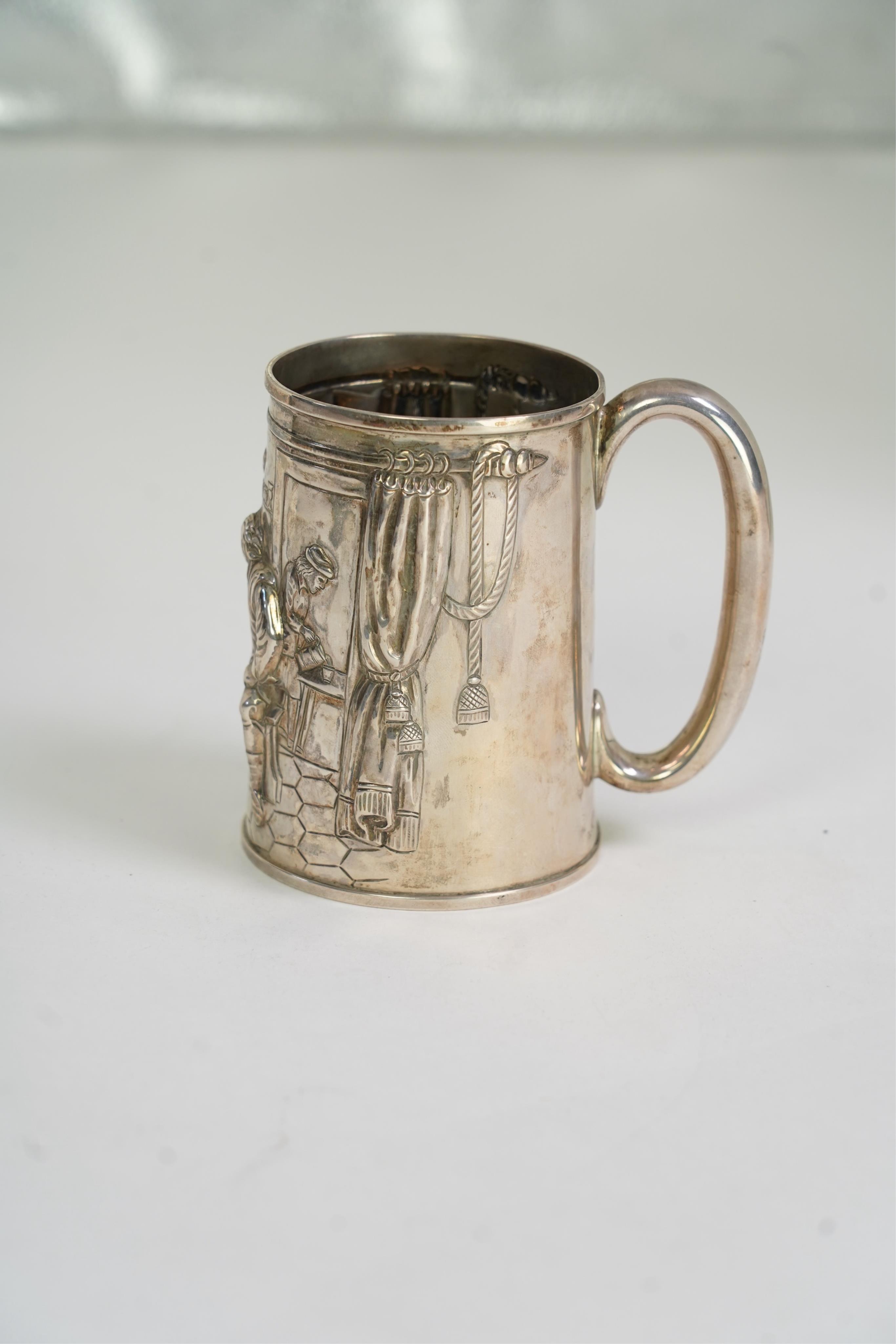 A Victorian silver mug, embossed with interior scene and imbibers, by John Harrison & Co